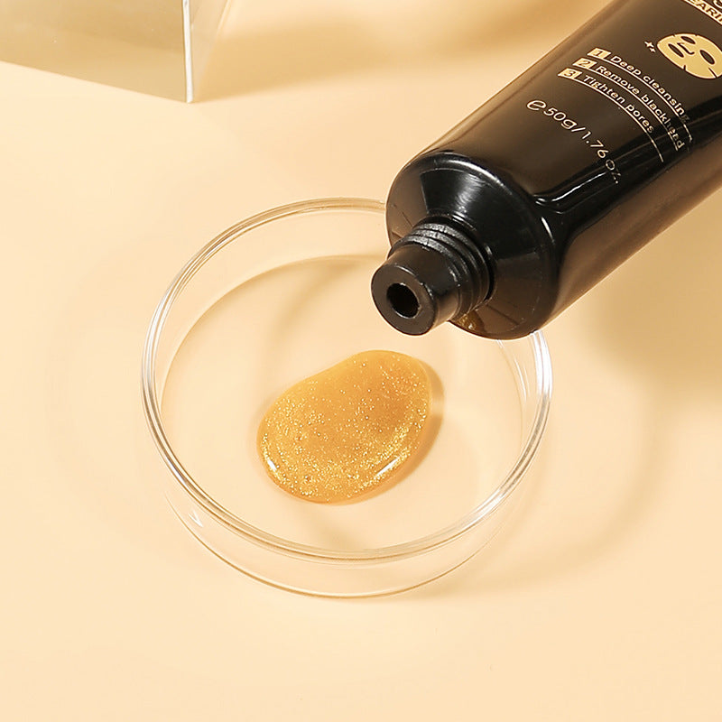 Organic and functional face mask squeezed from black tube into clear glass dish with beige background
