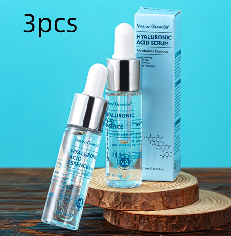 Three bottles of hyaluronic acid serum essence with dropper and packaging on wooden block organic and functional face mask